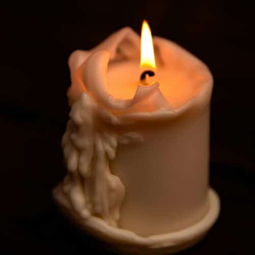 Α lit candle with melting wax drips